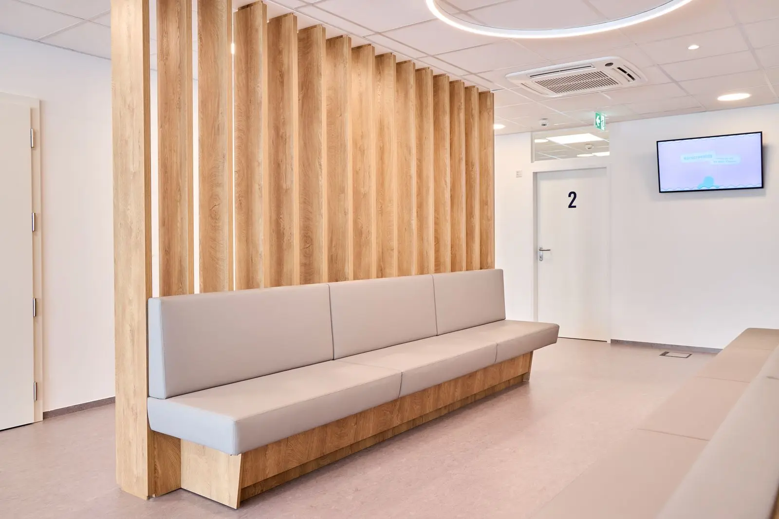 Der Wartebereich mit Wartebank und einem Raumtrenner in Holzoptik. Foto von Hans-Jürgen Vollnhofer.